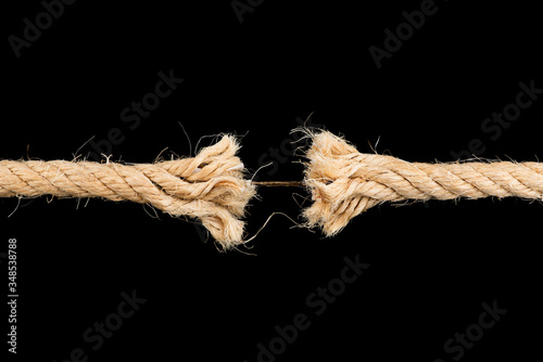 Frayed rope sting break torn isolated on black backgroud stress weakness concept