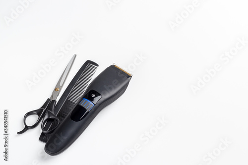 hair clipper, scissors and comb on a white background