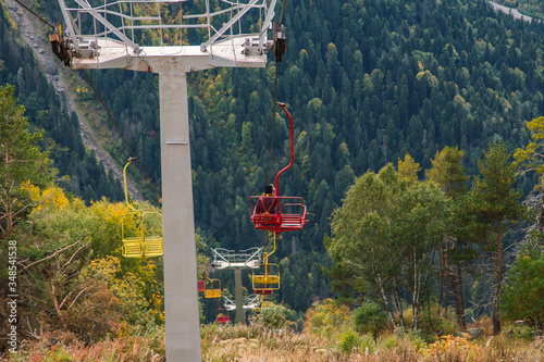 Old chairlift cableway in Dombay ski resort from the Mount Mussa Achitara in autumn, beautiful mountains landscape, snowy peaks, Caucasus, Russia photo