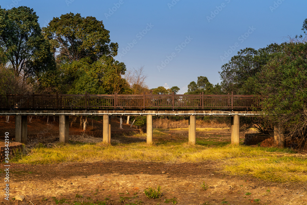 Wooden bridge over little river in city park