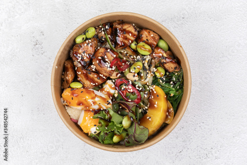 Φωτογραφία Poke bowl with chicken and vegetables on the white table.