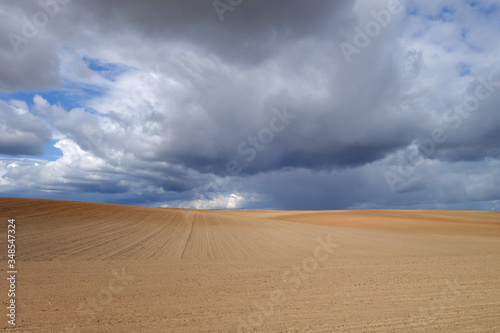 Cultivated agricultural field and cloudy sky.