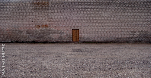Lonely wooden door on brick wall.