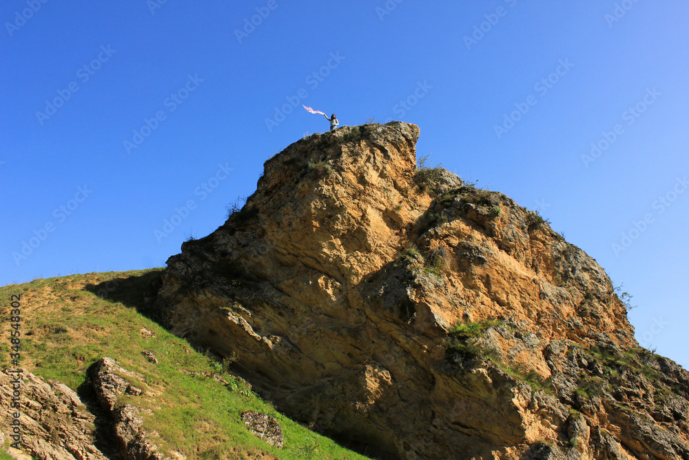 Azerbaijan. 08/04/2018 year. Girl with a scarf on a high rock. Azerbaijan. 08/04/2018 year. Girl with a scarf on a high rock.