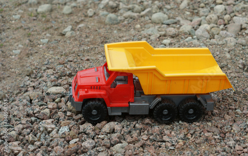 colorful plastic lorry toy on gravel road