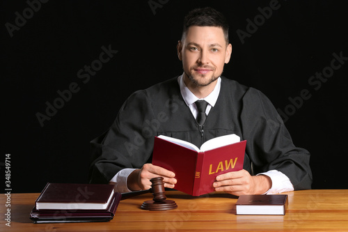Male judge with book at tab...