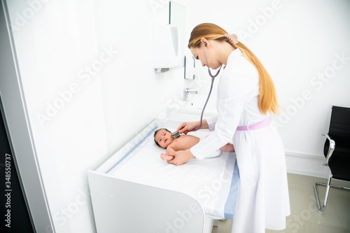 medicine, healthcare and pediatrics concept - female pediatrician or neuropathist doctor or nurse checking baby patient's at clinic or hospital photo