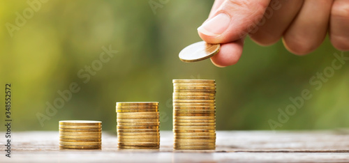 Growing gold money coins and hand, financial services concept, web banner with copy space photo