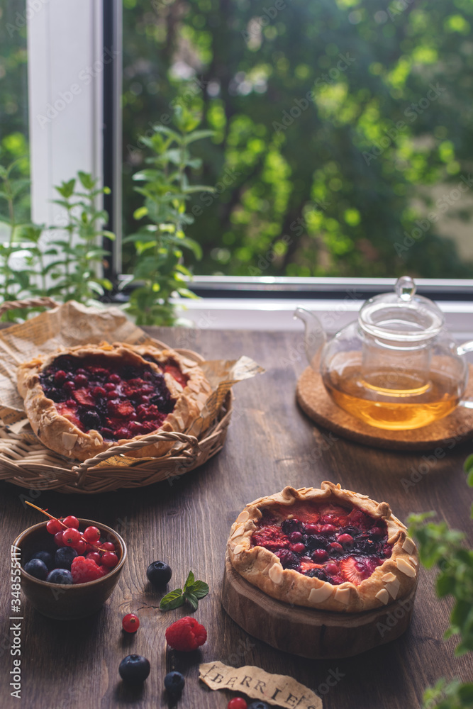 ummer homemade pastry, galette with berries on rustic wooden background ummer homemade pastry, galette with berries on rustic wooden background
