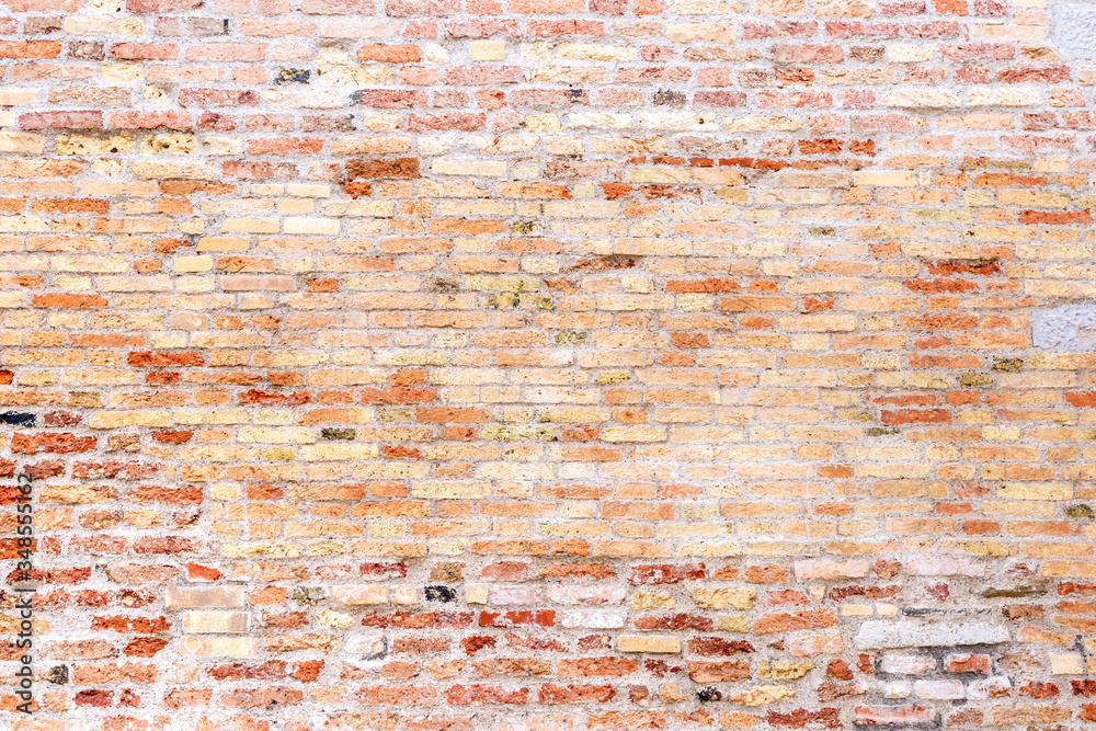 Eine alte verwitterte Ziegelmauer mit roten Ziegeln als Hintergrund