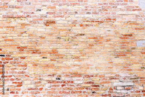 Eine alte verwitterte Ziegelmauer mit roten Ziegeln als Hintergrund