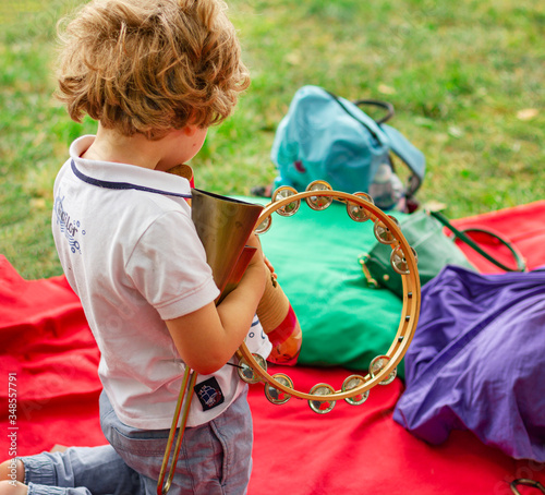 Little boy outdoor. The child plays percussion instruments.Summer educational camp for children