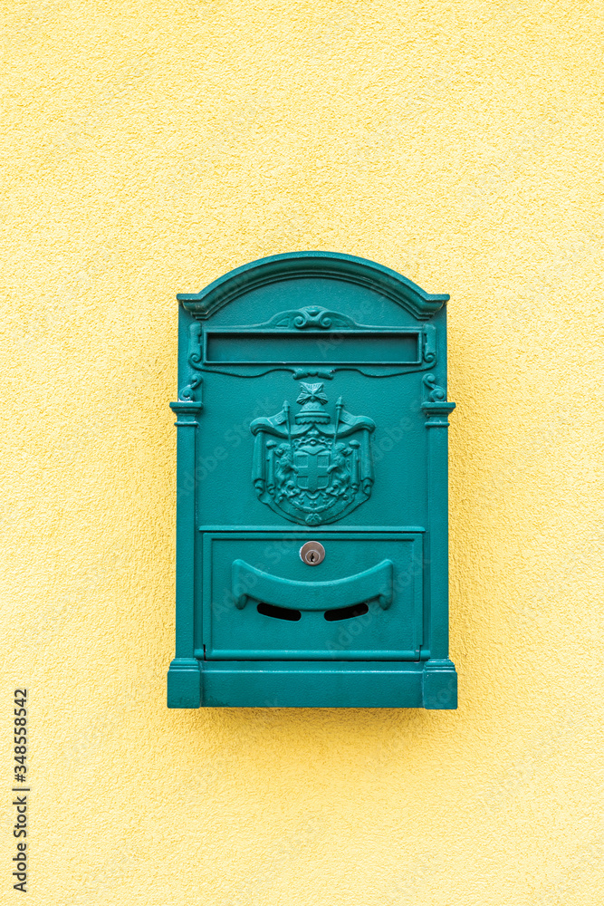 Gelbe Hausmauer mit einem grünen Postkasten als Hintergrund Gelbe Hausmauer mit einem grünen Postkasten als Hintergrund