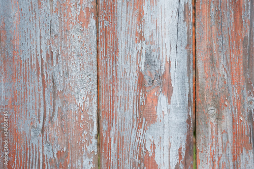 Old wide planks closeup background. Wooden background with peeling paint. Brown paint on the fence and gray slats. The texture of the wooden surface top view. Desk surface. Natural grunge boards