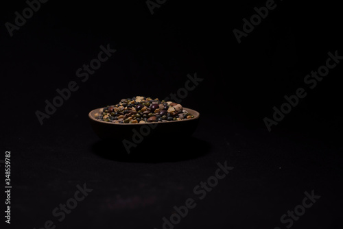 A bowl of Indian mixed pulses in a dark copy space background. Food and product photography.