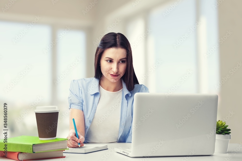 Young woman sitting at the desk with laptop Young woman sitting at the desk with laptop