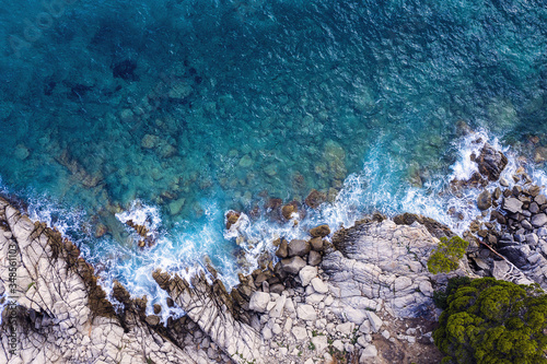 top view of rocky coast with clear blue sea