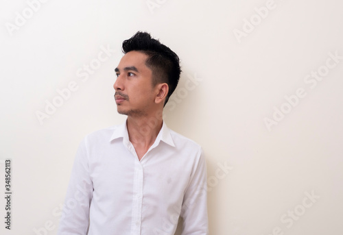 Young Asian man isolated on white background looking sideways