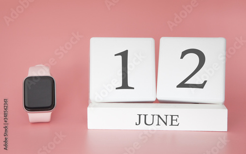 Modern Watch with cube calendar and date 12 june on pink background. Concept summer time vacation.