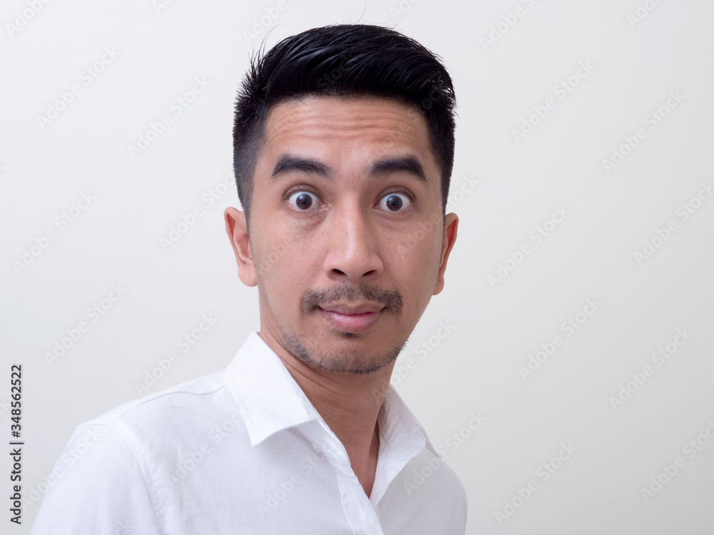 Shocked face of Asian man in white shirt on white background.