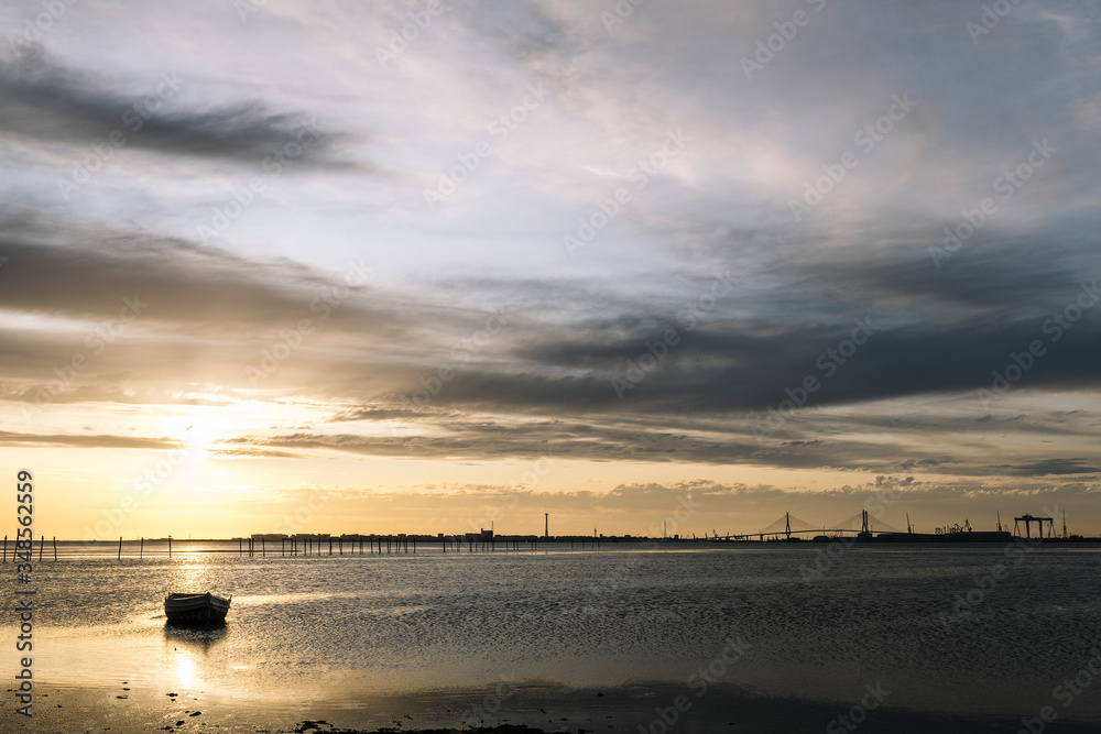 Obraz premium traditional wooden boat at sunset in the bay