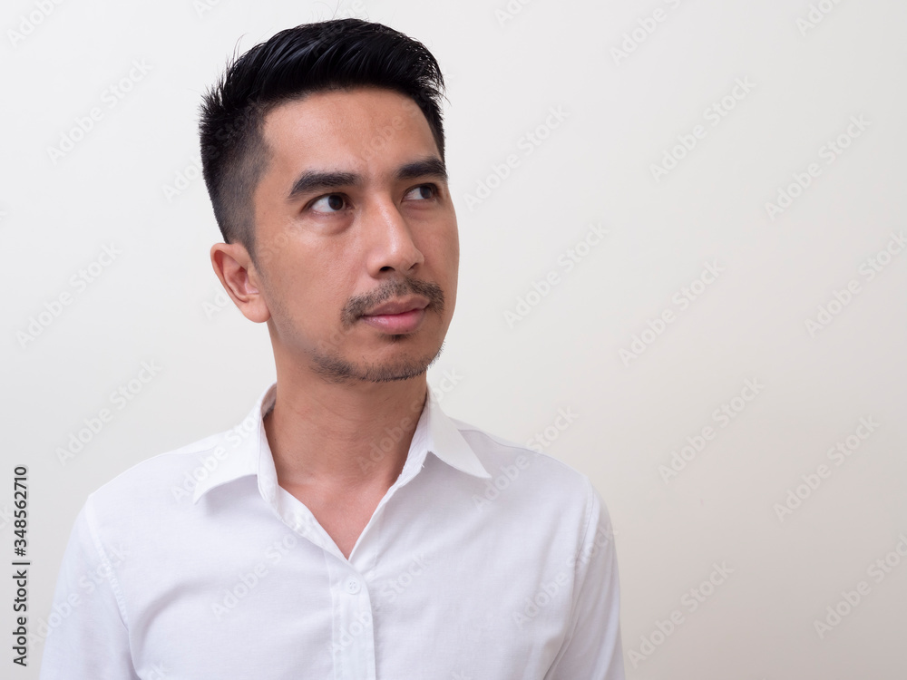 Portrait of Young funny Asian man with white shirt looking at camera Portrait of Young funny Asian man with white shirt looking at camera