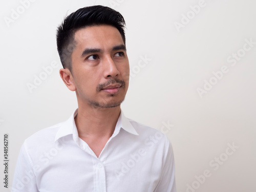 Portrait of Young funny Asian man with white shirt looking at camera © rufous