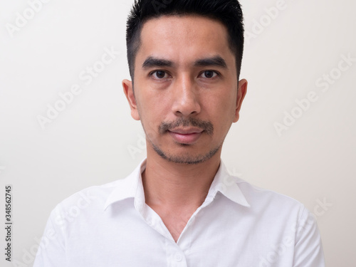 Portrait of Young funny Asian man with white shirt looking at camera