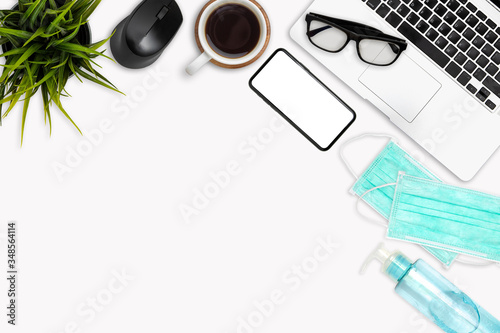 Work space office desk table top header at home layout on top have laptop, coffee cup, mock up phone solated, mask, alcohol gel work from home virus covid-19 scourge 