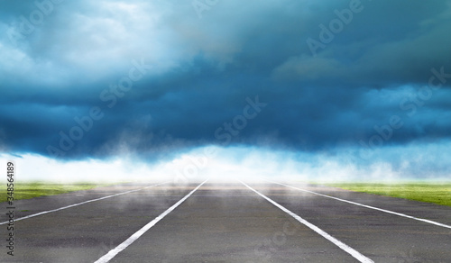 Road with asphalt, sky with clouds and sunlight against the horizon. Summer background © Laura Сrazy
