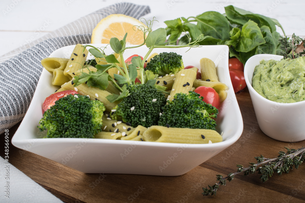 Gluten-free fresh cooked penne pasta from green peas isolated on wooden board. basil Gluten-free fresh cooked penne pasta from green peas isolated on wooden board. basil