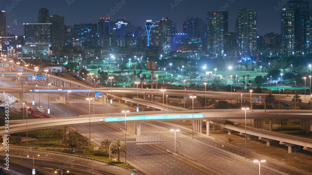 Obraz premium Aerial night view of empty highway and interchange without cars in Dubai