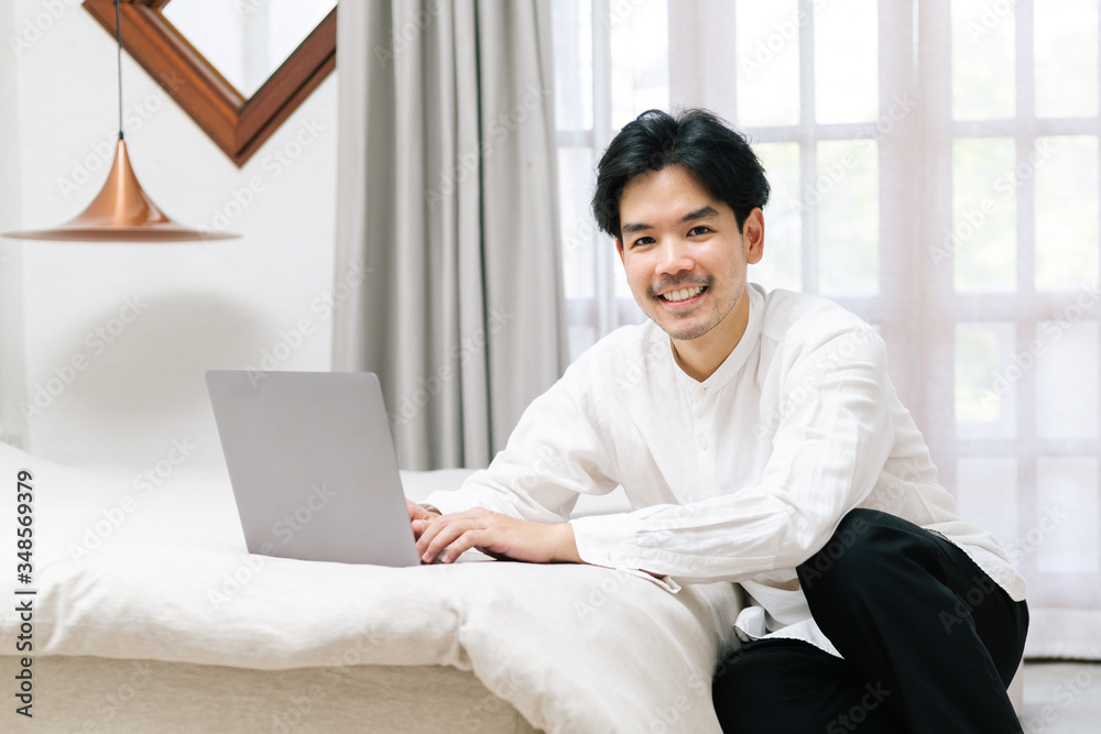 Attractive asian male working with computer laptop at home. Work from home concept. Attractive asian male working with computer laptop at home. Work from home concept.