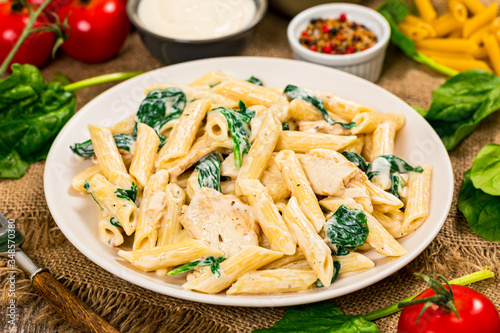 Chicken Alfredo with Spinach on Wooden Background. Selective focus.