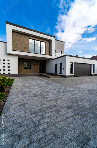 Cozy and modern house with garage and cobblestone driveway. Modern arhitecture. © Vadim