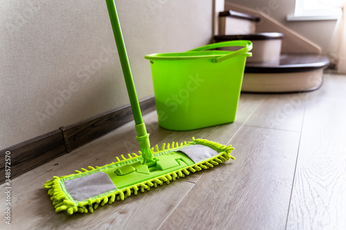 Mop with green microfiber rag  green plastic handle and bucket. Housekeeping concept.