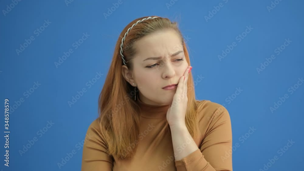 Toothache. Young woman feeling pain, holding her cheek with hand, suffering from bad tooth ache Toothache. Young woman feeling pain, holding her cheek with hand, suffering from bad tooth ache