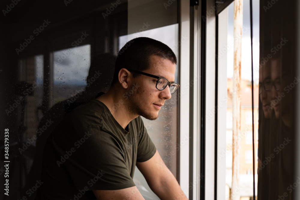 quarantined man looking out the window quarantined man looking out the window