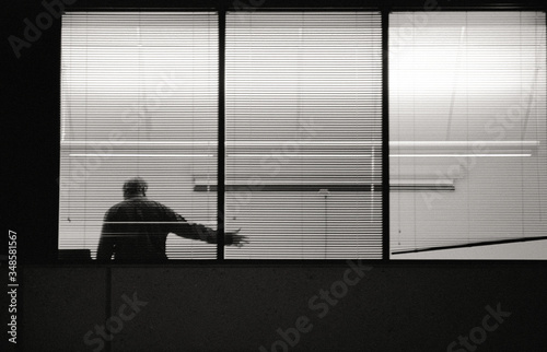 businessman making point seen through office window