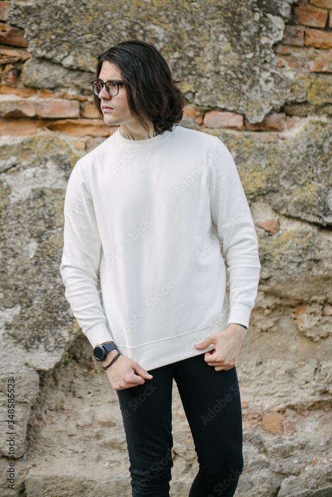 Man wearing white sweatshirt or hoodie and glasses outside on the city streets. Sweatshirt or hoodie for mock up, logo designs or design prints with free space. Man wearing white sweatshirt or hoodie and glasses outside on the city streets. Sweatshirt or hoodie for mock up, logo designs or design prints with free space.