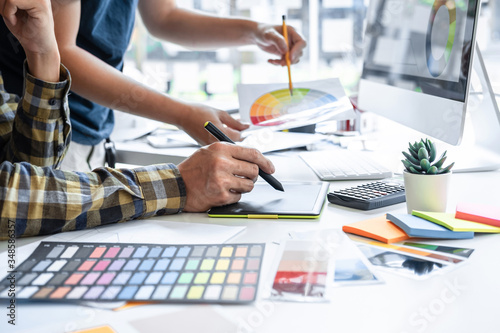 Team of young Interior graphic designer working sketching on graphic tablet and color swatch, discussing of house project at modern office, creative work place inspiration and imagine