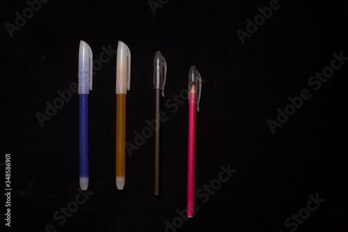 Colorful pens are arranged in a black copy space background. Object photography.