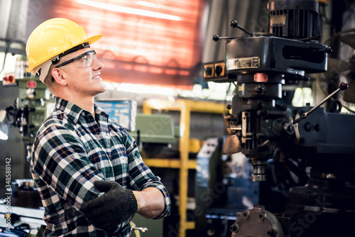Portrait images of Caucasian male engineer are standing and smiling at workplace Which is and industrial factory, with blur soft machinery background, to people and worker concept.