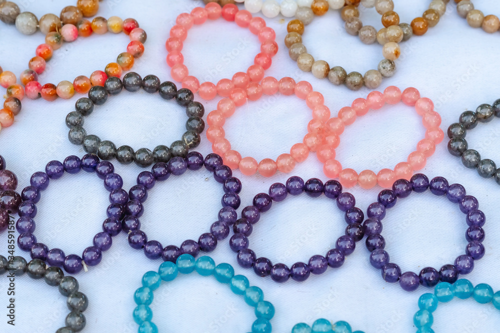 The colorful stone is used to make beautiful bracelets. Is a religious belief of Thai people that will have good luck for sale on the local market in Kanchanaburi, Thailand. Selective focus. The colorful stone is used to make beautiful bracelets. Is a religious belief of Thai people that will have good luck for sale on the local market in Kanchanaburi, Thailand. Selective focus.