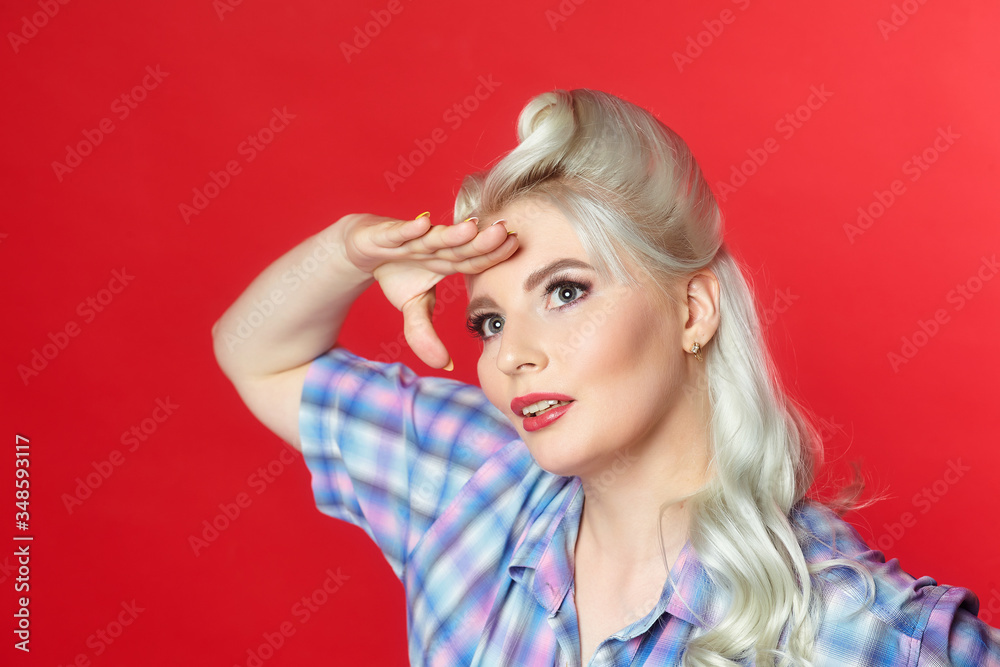 Fototapeta premium beautiful blonde with a big candy, posing on a red background