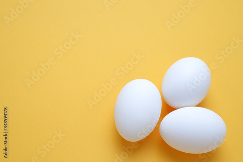 Eggs,Three White egg on the yellow background in center,Copy space for the ads