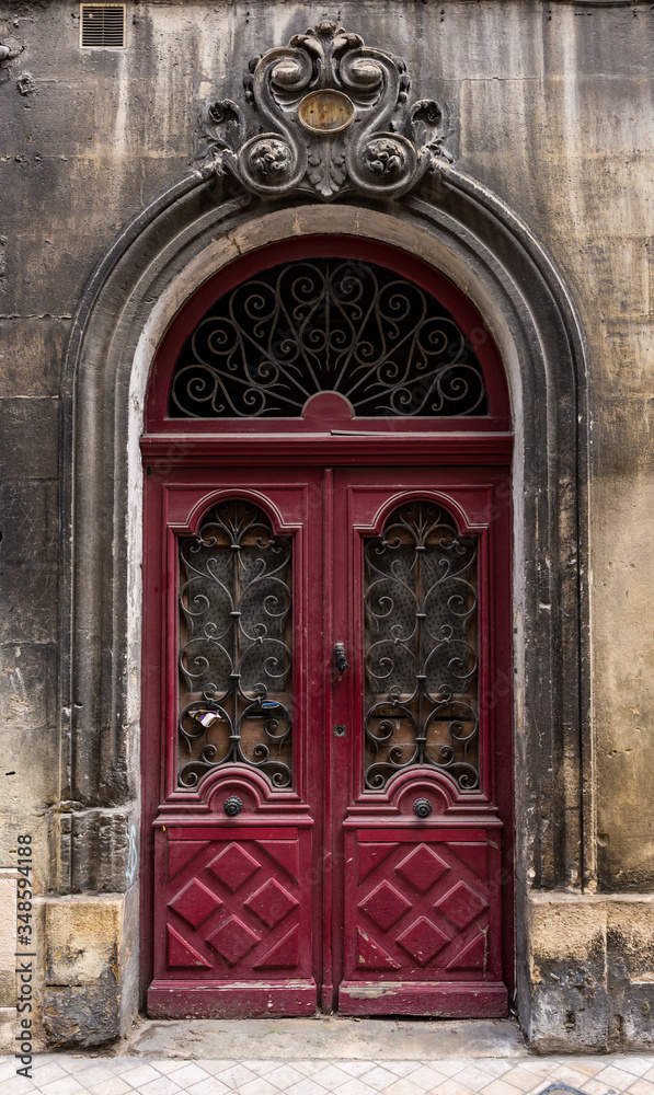 Old red wooden vintage archway doors in old town Bordeaux, France
