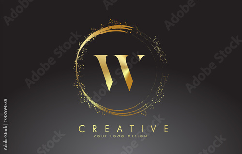 W golden letter logo with golden sparkling rings and dust glitter on a black background. Luxury decorative shiny vector illustration.