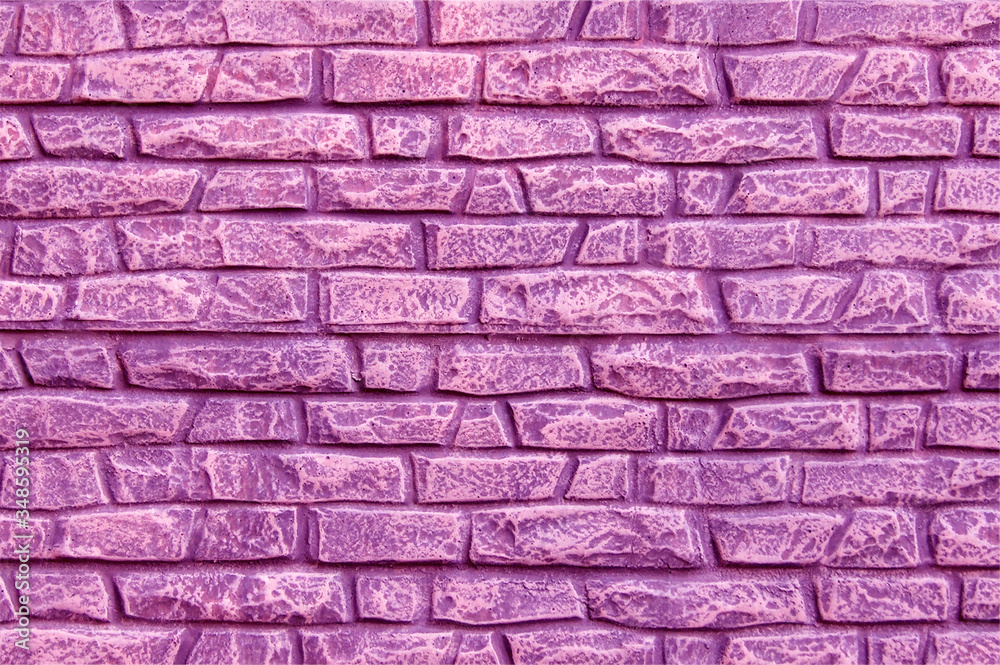 A modern stone fence in the form of an aged stone fence painted with pink paint.