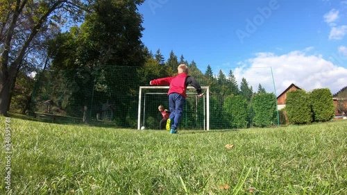 Young children playing soccer. The boy shoots at the goalkeeper and rejoices at the goal.
